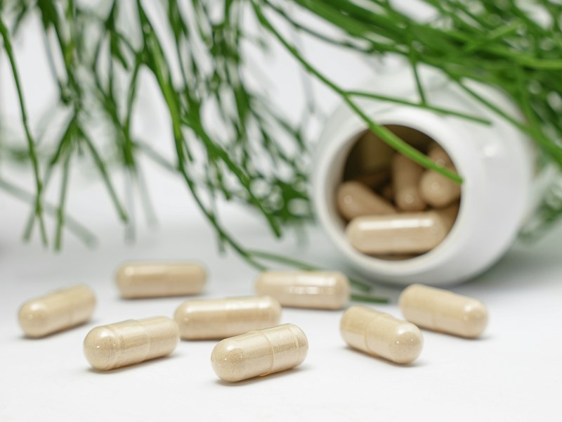 Calcium supplement capsules spilling from a bottle