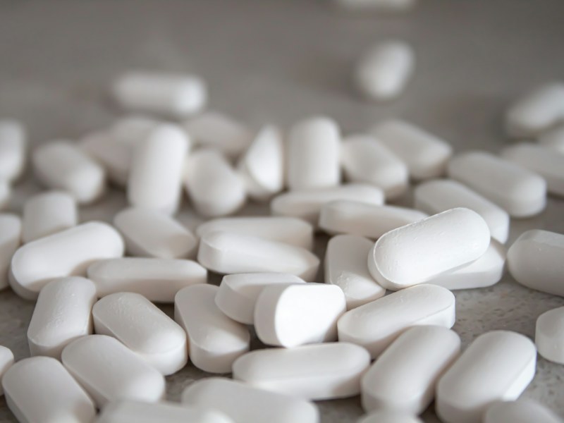 White calcium tablets on a wooden surface